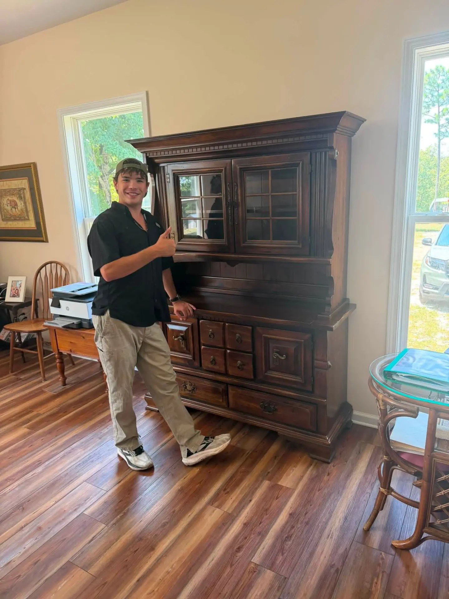 Title Town Junk Removal crew member preparing to move a large wooden hutch