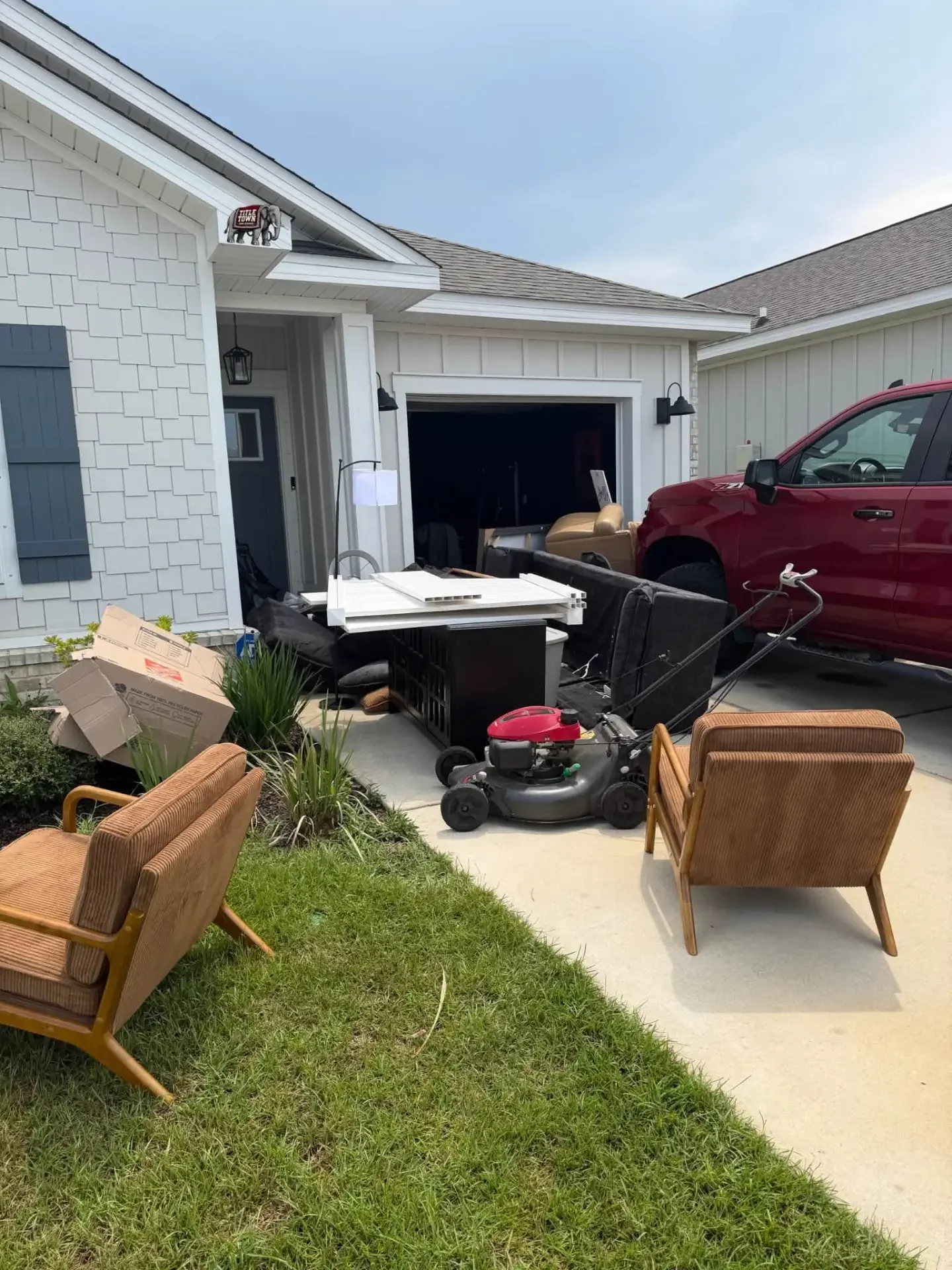 Furniture, boxes and household junk stacked in a driveway ready for pickup in Tuscaloosa